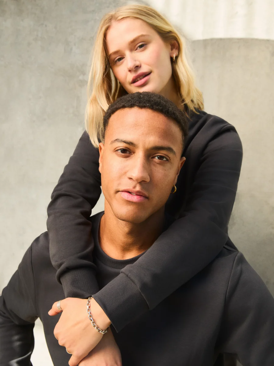 Zwei Personen tragen schwarze Jack & Jones Sweatshirts in urbaner Umgebung